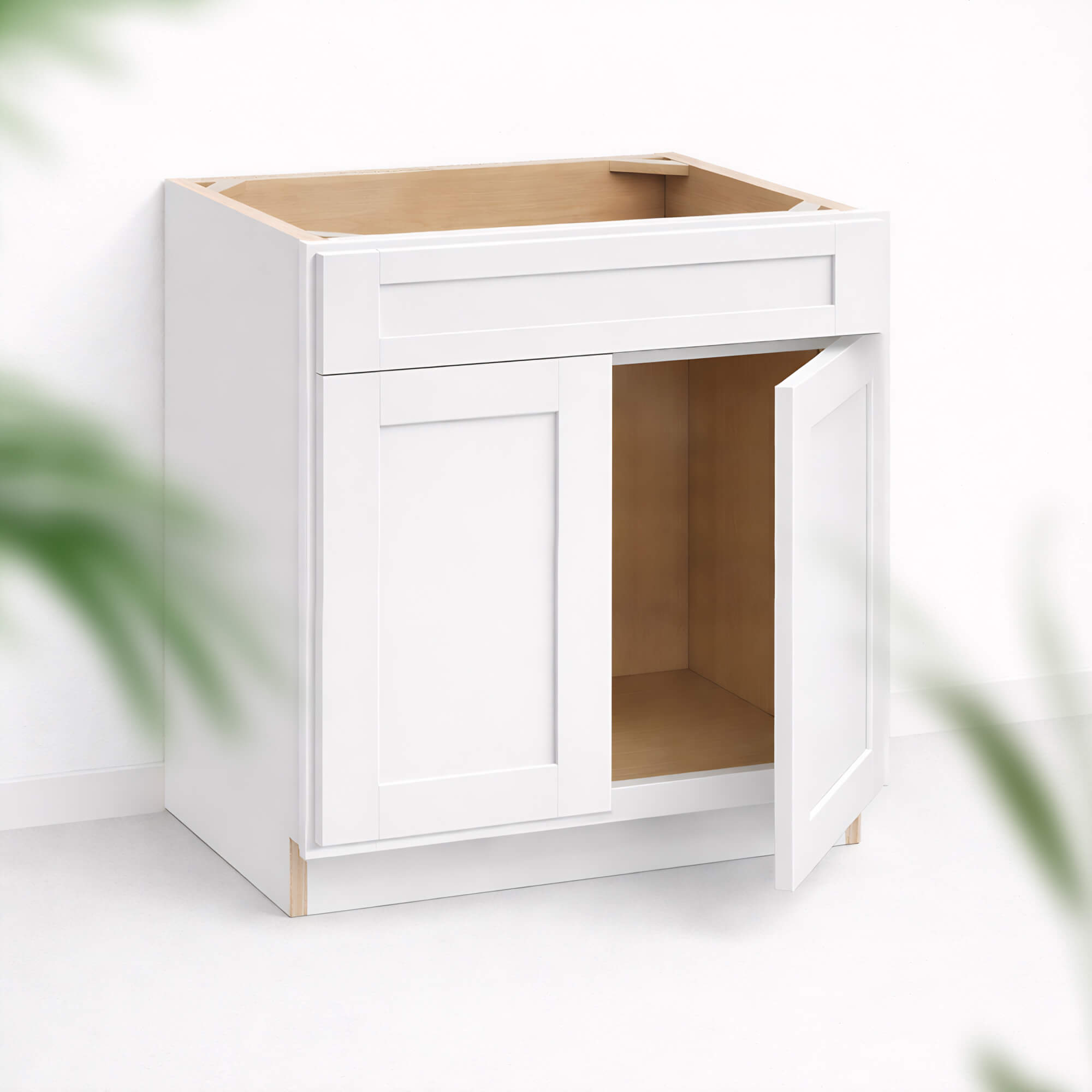 Base sink cabinet 34 1/2 inch height and 24 inch depth with Shaker style doors and top drawer front, one door partially open, white painted finish, frameless interior suitable for sink installation.