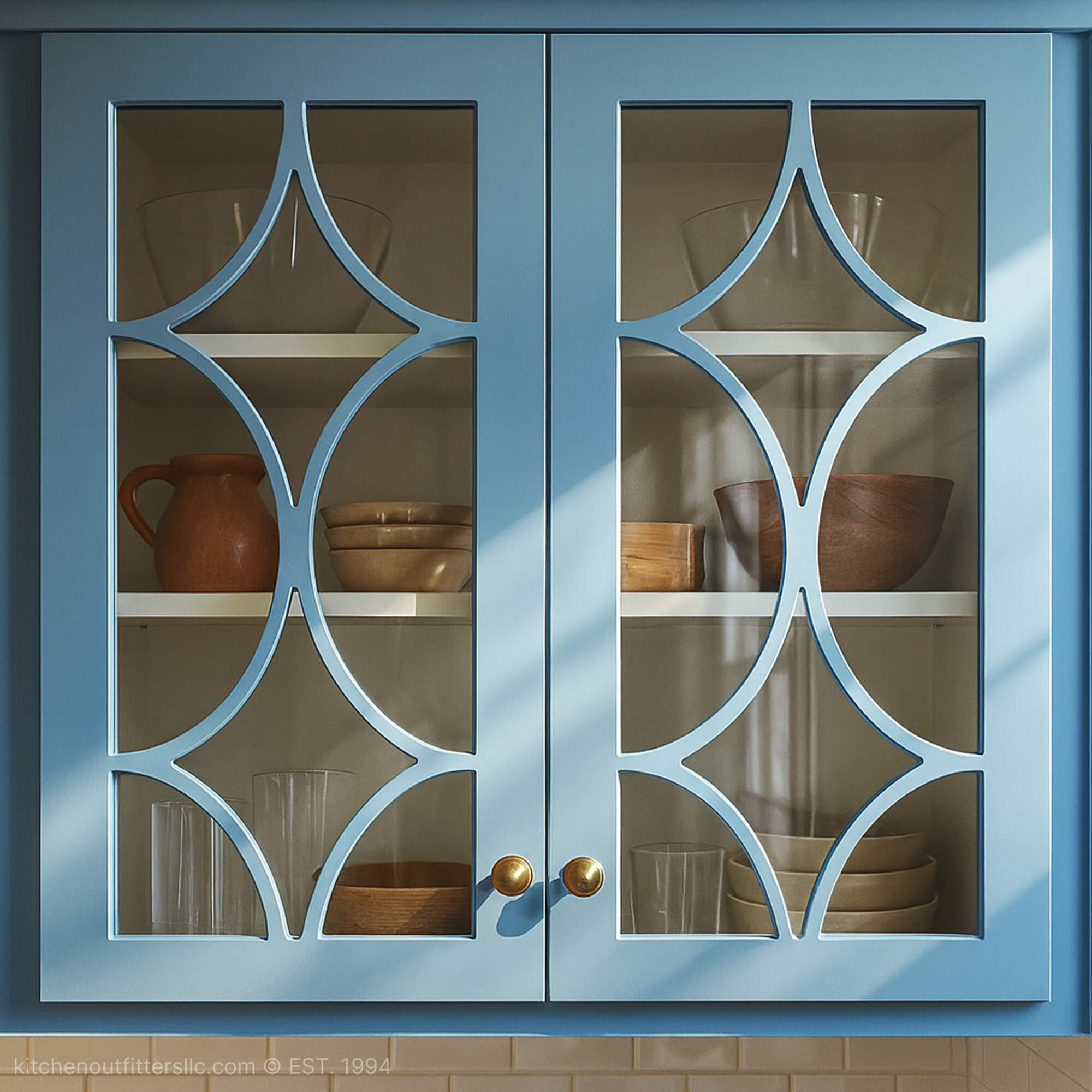 Diamond swag mullion glass cabinet doors in blue kitchen cabinet with decorative curved grid pattern and glass panels